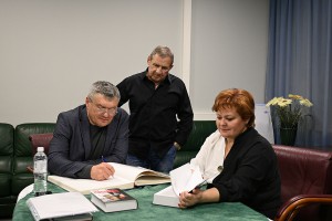 Сергей Козлов расписывается в книге гостей библиотек Сургута